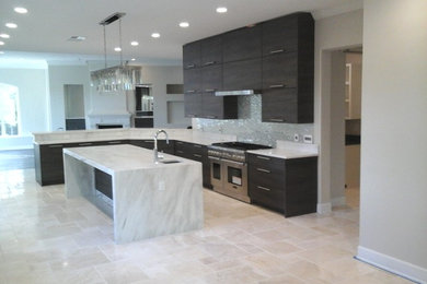 Eat-in kitchen - huge contemporary u-shaped travertine floor and beige floor eat-in kitchen idea in Orlando with a farmhouse sink, flat-panel cabinets, gray cabinets, marble countertops, metallic backsplash, mosaic tile backsplash, stainless steel appliances, an island and beige countertops