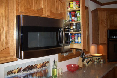 Modelo de cocina de tamaño medio con puertas de armario de madera oscura, encimera de acrílico, electrodomésticos de acero inoxidable y una isla