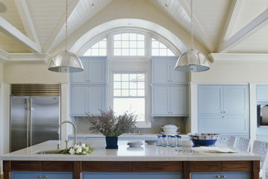 Immagine di una cucina abitabile con lavello sottopiano, ante con bugna sagomata, ante blu, top in granito, paraspruzzi a effetto metallico e elettrodomestici in acciaio inossidabile