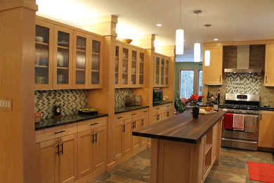 Inredning av ett modernt stort kök och matrum, med en undermonterad diskho, släta luckor, skåp i ljust trä, granitbänkskiva, beige stänkskydd, stänkskydd i stenkakel, rostfria vitvaror, klinkergolv i porslin och en köksö