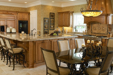 Eat-in kitchen - huge transitional l-shaped travertine floor eat-in kitchen idea in Jacksonville with an undermount sink, raised-panel cabinets, light wood cabinets, granite countertops, beige backsplash, paneled appliances and an island