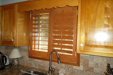 Foto de cocinas en L tradicional de tamaño medio cerrada con puertas de armario de madera oscura, encimera de granito y electrodomésticos de acero inoxidable