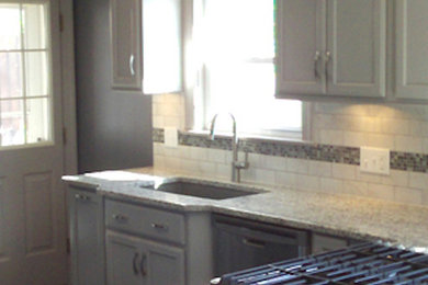 Example of a kitchen design in Philadelphia with a farmhouse sink, recessed-panel cabinets, white cabinets and stainless steel appliances