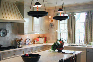 Modelo de cocina clásica con armarios estilo shaker, puertas de armario blancas, electrodomésticos de acero inoxidable y una isla