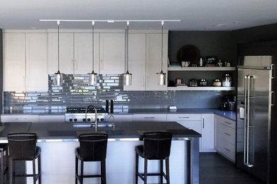 Design ideas for a contemporary kitchen in Grand Rapids with white cabinets, quartz worktops and an island.