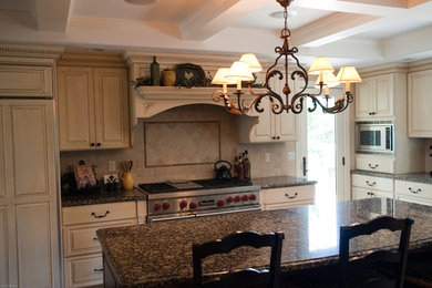 Mid-sized elegant l-shaped kitchen photo in Denver with raised-panel cabinets, white cabinets, granite countertops, beige backsplash, ceramic backsplash, paneled appliances and an island
