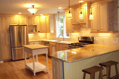 Mid-sized elegant l-shaped light wood floor eat-in kitchen photo in Boston with a drop-in sink, raised-panel cabinets, white cabinets, granite countertops, gray backsplash, ceramic backsplash, stainless steel appliances and an island