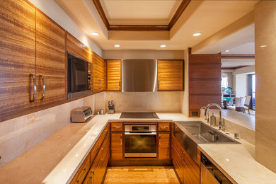 Small minimalist galley bamboo floor enclosed kitchen photo in San Diego with a farmhouse sink, light wood cabinets, marble countertops, beige backsplash, stainless steel appliances, no island, flat-panel cabinets and marble backsplash