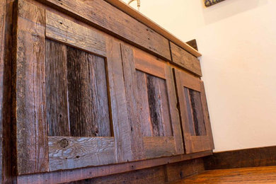 Ejemplo de cocina lineal rústica con armarios con paneles lisos, puertas de armario de madera en tonos medios y encimera de laminado