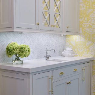 Immagine di un'ampia cucina ad U stile shabby con lavello stile country, ante a filo, ante bianche, top in quarzo composito, paraspruzzi grigio, paraspruzzi con piastrelle in pietra, elettrodomestici in acciaio inossidabile, parquet scuro e isola