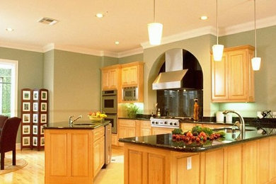 Источник вдохновения для домашнего уюта: угловая кухня в классическом стиле с светлыми деревянными фасадами, черным фартуком и техникой из нержавеющей стали
