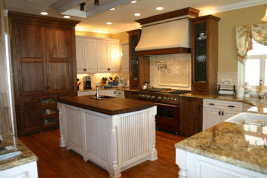 Large elegant u-shaped dark wood floor and brown floor kitchen photo in Albuquerque with raised-panel cabinets, granite countertops, beige backsplash, stainless steel appliances, an island, a farmhouse sink, white cabinets and ceramic backsplash