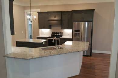 Example of a mid-sized arts and crafts l-shaped medium tone wood floor and brown floor eat-in kitchen design in Other with shaker cabinets, gray cabinets, granite countertops, stainless steel appliances, an island, an undermount sink and gray countertops