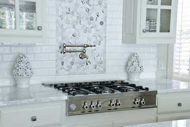 ダラスにあるコンテンポラリースタイルのおしゃれなキッチン (インセット扉のキャビネット、白いキャビネット、大理石カウンター、白いキッチンパネル、サブウェイタイルのキッチンパネル、シルバーの調理設備) の写真