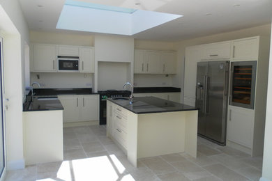 Large classic u-shaped kitchen/diner in Kent with a belfast sink, beaded cabinets, granite worktops, coloured appliances, ceramic flooring and an island.