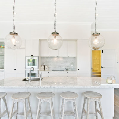 Open concept kitchen - transitional single-wall light wood floor and gray floor open concept kitchen idea in Perth with an undermount sink, shaker cabinets, white cabinets, gray backsplash, stainless steel appliances and an island