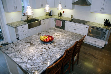 Immagine di una cucina minimalista di medie dimensioni con lavello stile country, ante in stile shaker, ante bianche, top in granito, paraspruzzi bianco, paraspruzzi con piastrelle di vetro, elettrodomestici in acciaio inossidabile, pavimento in ardesia e pavimento grigio