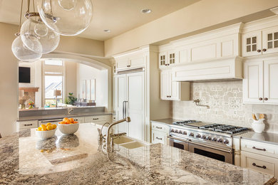 Example of a mid-sized transitional l-shaped enclosed kitchen design in Nashville with a farmhouse sink, beaded inset cabinets, white cabinets, granite countertops, gray backsplash, subway tile backsplash, paneled appliances and an island