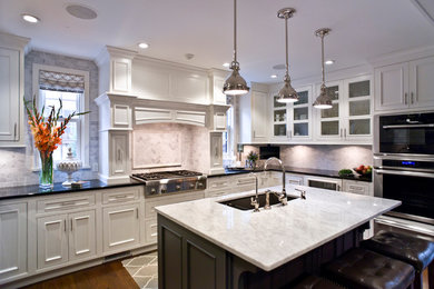 Inspiration for a mid-sized transitional u-shaped medium tone wood floor and brown floor eat-in kitchen remodel in Other with an undermount sink, beaded inset cabinets, white cabinets, quartz countertops, multicolored backsplash, subway tile backsplash, stainless steel appliances and an island