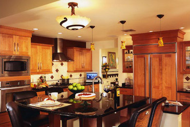 Foto de cocina grande con puertas de armario de madera oscura, electrodomésticos de acero inoxidable y una isla
