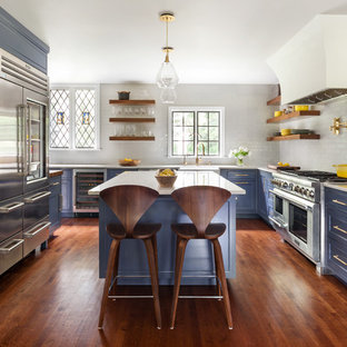 Esempio di una cucina tradizionale con lavello stile country, ante con riquadro incassato, ante viola, paraspruzzi bianco, elettrodomestici in acciaio inossidabile, pavimento in legno massello medio, pavimento marrone e top bianco