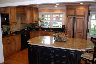 Design ideas for a traditional kitchen in Other with an island, medium wood cabinets, black appliances, a double-bowl sink and medium hardwood flooring.