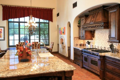 フェニックスにある高級な広いおしゃれなキッチン (アンダーカウンターシンク、中間色木目調キャビネット、御影石カウンター、白いキッチンパネル、シルバーの調理設備、テラコッタタイルの床) の写真