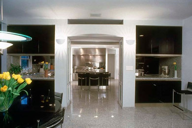 Example of a huge minimalist u-shaped marble floor eat-in kitchen design in New York with an undermount sink, flat-panel cabinets, black cabinets, granite countertops, gray backsplash, stone slab backsplash, stainless steel appliances and an island