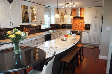 Large transitional l-shaped medium tone wood floor and brown floor eat-in kitchen photo in Philadelphia with an undermount sink, raised-panel cabinets, white cabinets, granite countertops, black backsplash, ceramic backsplash, stainless steel appliances and an island