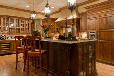 Kitchen - large l-shaped light wood floor kitchen idea in Other with medium tone wood cabinets, granite countertops, brown backsplash, paneled appliances and an island