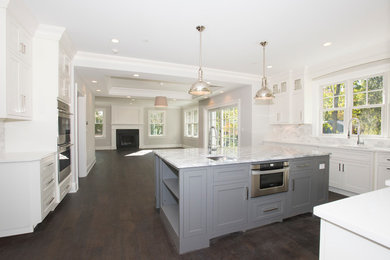Mid-sized transitional l-shaped dark wood floor and brown floor open concept kitchen photo in New York with an undermount sink, recessed-panel cabinets, white cabinets, granite countertops, multicolored backsplash, mosaic tile backsplash, stainless steel appliances, an island and gray countertops