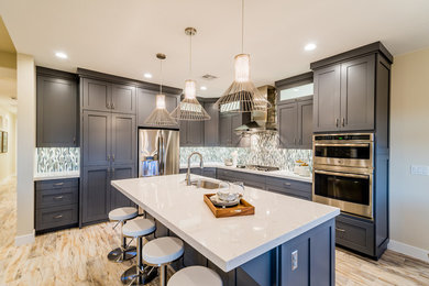 Example of a large trendy l-shaped vinyl floor eat-in kitchen design in Salt Lake City with an undermount sink, shaker cabinets, gray cabinets, marble countertops, gray backsplash, matchstick tile backsplash, stainless steel appliances and an island