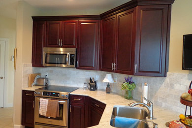 Example of a large classic u-shaped ceramic tile enclosed kitchen design in Miami with a double-bowl sink, raised-panel cabinets, dark wood cabinets, beige backsplash, ceramic backsplash, stainless steel appliances and no island