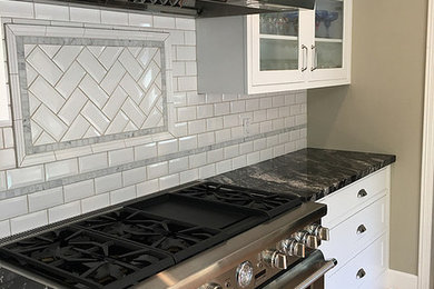 Kitchen - transitional light wood floor and brown floor kitchen idea in San Francisco with shaker cabinets, white cabinets, granite countertops, white backsplash, ceramic backsplash and stainless steel appliances