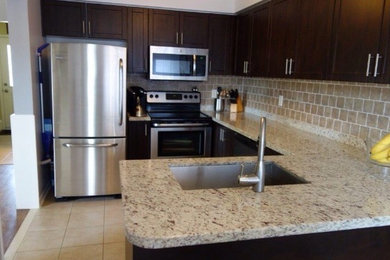 Example of a mid-sized transitional u-shaped ceramic tile kitchen design in Orange County with an undermount sink, shaker cabinets, dark wood cabinets, granite countertops, beige backsplash, ceramic backsplash and stainless steel appliances