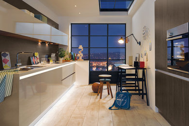 Cette image montre une cuisine parallèle design fermée et de taille moyenne avec un placard à porte plane, des portes de placard beiges et parquet clair.