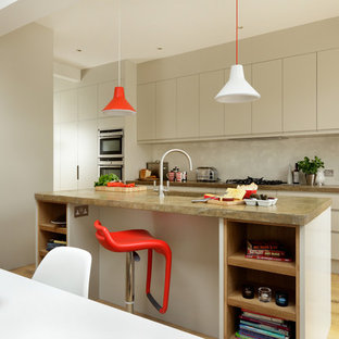 Inspiration for a mid-sized contemporary galley eat-in kitchen in Other with flat-panel cabinets, beige cabinets, beige splashback, stainless steel appliances, multiple islands, brown floor, an integrated sink and light hardwood floors.