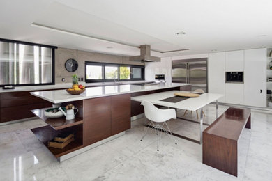 Large contemporary l-shaped enclosed kitchen in New York with flat-panel cabinets, white cabinets, engineered stone countertops, grey splashback, cement tile splashback, stainless steel appliances, marble flooring, an island and white floors.