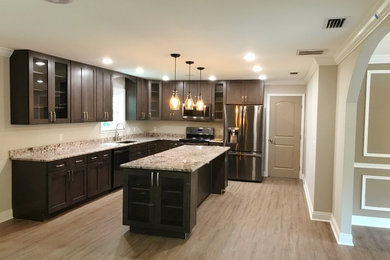 Large transitional l-shaped light wood floor and beige floor eat-in kitchen photo in Other with an undermount sink, shaker cabinets, dark wood cabinets, granite countertops, stainless steel appliances, an island and beige countertops