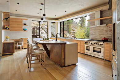 Enclosed kitchen - large contemporary u-shaped light wood floor and beige floor enclosed kitchen idea in Boise with a farmhouse sink, flat-panel cabinets, light wood cabinets, concrete countertops, gray backsplash, cement tile backsplash, paneled appliances and an island
