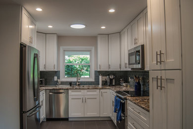 Example of a mid-sized classic u-shaped porcelain tile and gray floor enclosed kitchen design in DC Metro with an undermount sink, shaker cabinets, white cabinets, granite countertops, blue backsplash, subway tile backsplash, stainless steel appliances, no island and multicolored countertops