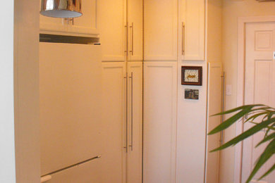 プロビデンスにあるおしゃれなキッチン (落し込みパネル扉のキャビネット、白いキャビネット、御影石カウンター、白いキッチンパネル、白い調理設備、濃色無垢フローリング) の写真