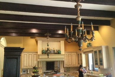 フェニックスにある広いトラディショナルスタイルのおしゃれなキッチン (落し込みパネル扉のキャビネット、淡色木目調キャビネット、御影石カウンター、ベージュキッチンパネル、石タイルのキッチンパネル、トラバーチンの床) の写真