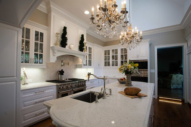 Eat-in kitchen - large traditional u-shaped medium tone wood floor and brown floor eat-in kitchen idea in DC Metro with a double-bowl sink, glass-front cabinets, white cabinets, quartzite countertops, white backsplash, ceramic backsplash, stainless steel appliances and an island