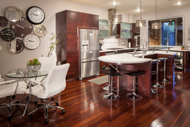 Eat-in kitchen - mid-sized contemporary l-shaped medium tone wood floor eat-in kitchen idea in Other with a double-bowl sink, glass-front cabinets, stainless steel appliances and an island