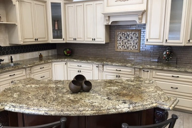 Inspiration for a mid-sized timeless l-shaped ceramic tile open concept kitchen remodel in Orange County with raised-panel cabinets, white cabinets, granite countertops, gray backsplash, subway tile backsplash, paneled appliances, an island and a double-bowl sink