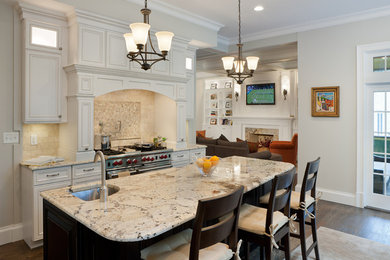 ボストンにあるトラディショナルスタイルのおしゃれなキッチン (白いキャビネット、ベージュキッチンパネル、シルバーの調理設備) の写真