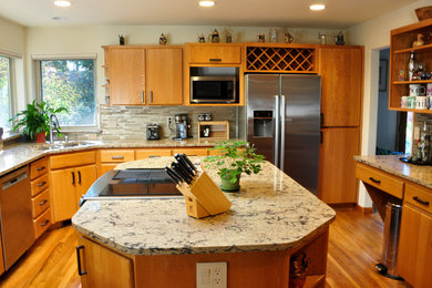 Example of a mid-sized trendy medium tone wood floor and brown floor kitchen design in Seattle with an undermount sink, flat-panel cabinets, medium tone wood cabinets, granite countertops, beige backsplash, matchstick tile backsplash, white appliances and an island