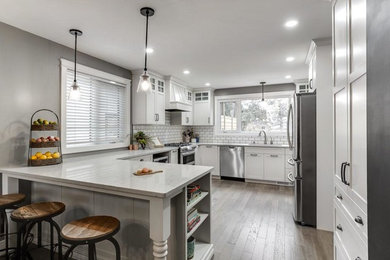 Foto de cocina moderna de tamaño medio sin isla con armarios con paneles lisos, puertas de armario blancas, encimera de cuarcita, suelo laminado y suelo gris