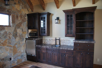 Idéer för ett kök, med en enkel diskho, luckor med infälld panel, skåp i mörkt trä, granitbänkskiva, beige stänkskydd, stänkskydd i stenkakel, rostfria vitvaror och ljust trägolv